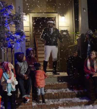 village people standing on porch with snow and children