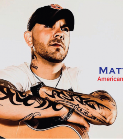 matt williams wearing white tshirt crossing arms over acoustic guitar with american flag